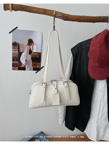 Detailed macro view of the cream white vintage shoulder bag with dual silver metal zippers