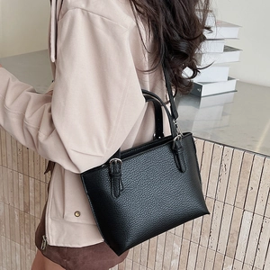 Detail showing high-quality black lychee texture leather on a vintage bucket handbag
