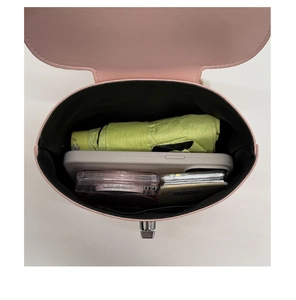 Top view of pink crossbody bag showing spacious interior with phone, umbrella and cosmetics
