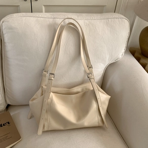Close-up of adjustable silver buckle strap on a cream minimalist tote bag