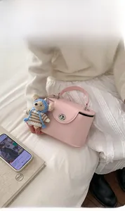 Pink crossbody box bag with silver twist lock and cute knitted bear charm accessory
