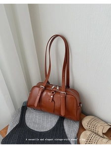 Close-up of a brown vintage Boston bag with silver buckles and elegant top handles