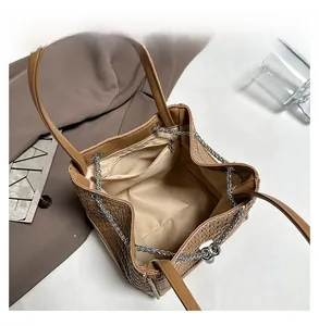 Detailed interior view of a brown woven bucket bag with inner lining and zipper pocket