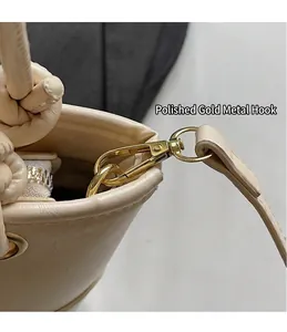 Gedetailleerde opname van gouden metalen haken en ritssluiting van de beige tas
