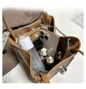 Detail display showing the large interior capacity of the brown woven leather bucket bag