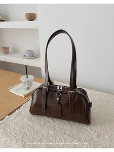 Detailed close-up of dark brown vintage shiny leather texture and silver buckle accents