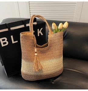 Detail of hand-woven gradient straw tote bag with fringe tassels and tulip decoration