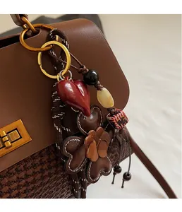 Detailed macro view of creative red heart and leather flower bag charm with beads