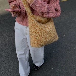 Detail of soft leopard print faux fur tote bag styled with a pink knitted sweater
