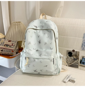 Detail of light blue nylon backpack with butterfly print and AKDBAG side label
