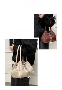 Close-up of woven bucket bag featuring chain drawstring and elegant pearl pendant detail