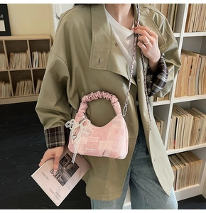 Detailed side view of pink plaid pleated dumpling bag with pearl and lace bow charm