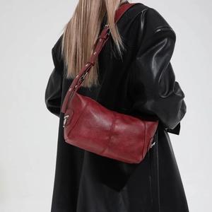 Detailed view of the dark red dumpling bag with vintage texture and silver hardware details