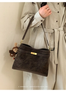 Détail du sac cabas vintage marron avec coutures contrastées et fermoir doré rotatif