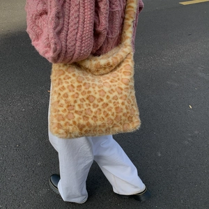 Detail showing the soft leopard print faux fur texture of the oversized shoulder tote bag