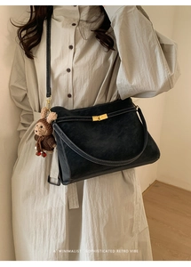 Détail du sac cabas noir avec coutures blanches contrastées et un charm ours mignon