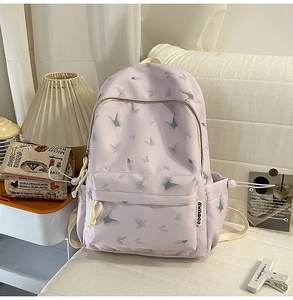 Detail view of light purple nylon backpack with butterfly print and side drawstring pockets