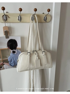 Detail of vintage cream white shoulder bag with glossy leather texture and silver hardware