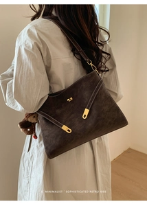 Vue détaillée du grand sac cabas rétro marron foncé avec boucles dorées et charm d'ourson
