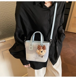 Vue détaillée du sac cabas bicolore avec charm ours et bandoulière réglable