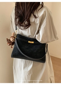 Détail d'un sac cabas rétro noir avec surpiqûres blanches et charm petit ours marron