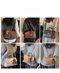 Rear view of model wearing woven texture crossbody bag with floral heart pendant