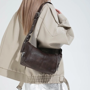 Close-up of retro dark brown leather shoulder bag with vintage texture and metal zipper