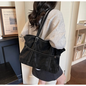 Detail view of black vintage tote bag with contrast stitching and adjustable buckles