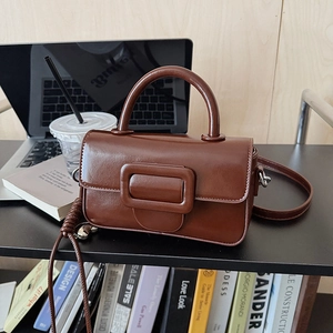 Detailed macro view of the vintage brown crossbody square bag's smooth faux leather texture