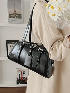 Minimalist black glossy leather bowling shoulder bag with adjustable straps for women