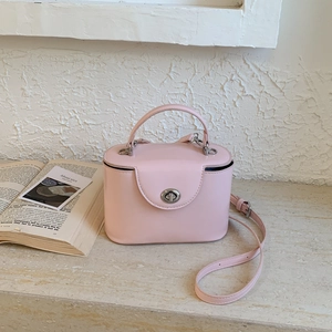 Detail of pink patent leather box bag with silver twist lock and detachable shoulder strap
