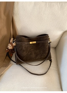 Détail du sac cabas rétro marron avec fermoir doré et charmant pendentif ours
