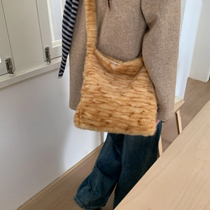 Close-up of the orange and brown striped faux fur texture on a large hobo shoulder bag