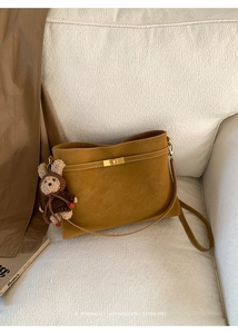 Détail du sac fourre-tout rétro jaune gingembre avec fermoir doré et charme d'ours mignon