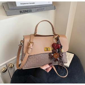 Detail of retro tote bag with tweed texture, gold twist lock, and floral heart charm