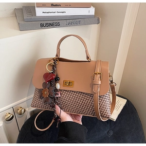 Detail of vintage patchwork tote with woven texture, gold clasp, and heart charm