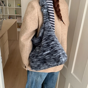 Detail of grey leopard print faux fur hobo bag showing texture and plush material