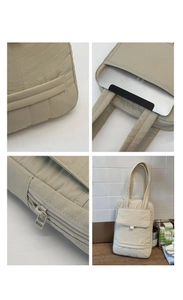 Detail view of beige quilted laptop bag showing zippers and multiple storage compartments
