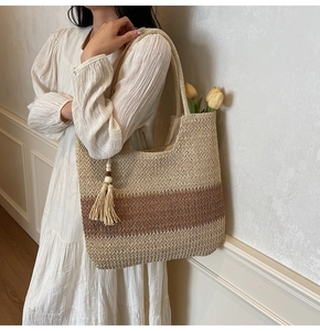 Detail view of woven beach tote bag with gradient brown texture and decorative long tassels