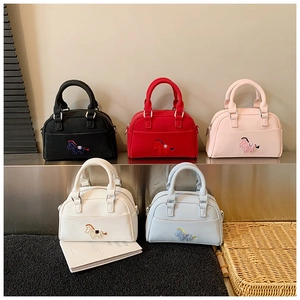 Détail de cinq mini sacs à main carrés avec broderie poney en noir, rouge, rose et blanc