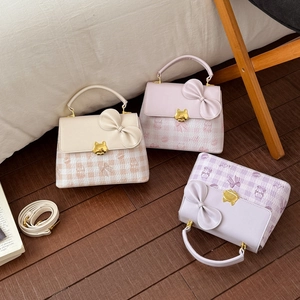 Detailed view of luxury square bags with bow decoration and golden cat-shaped clasps