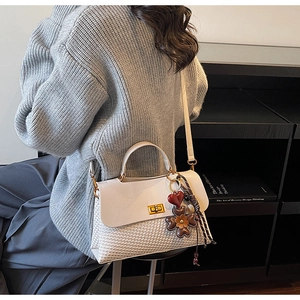 Detailed back view of a white mixed-material handbag with gold lock and floral charms