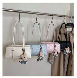 Detail view of stylish square shoulder bags in four colors with cute teddy bear charms