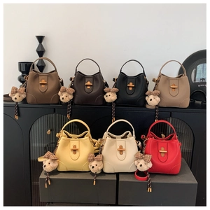 Collection of seven colorful litchi leather bucket bags with gold twist locks and bear charms
