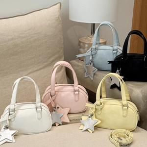 Detailed view of mini Boston bags in five colors with star charms and adjustable straps