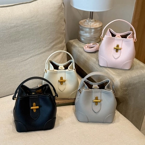 Detail view of colorful bucket bags in lychee leather with golden T-shape locks