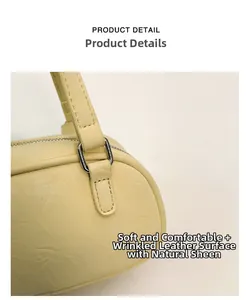 Close-up of cream Boston bag featuring ruched leather texture and silver hardware links