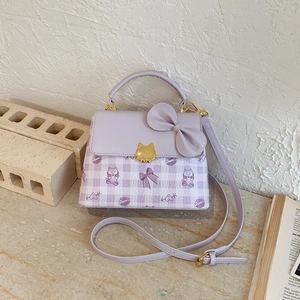 Close-up of light purple square bag with a large bow and golden kitten metal buckle detail
