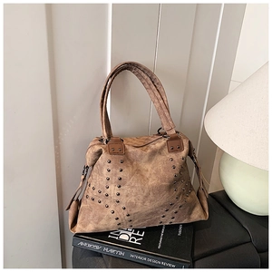 Gros plan d'un sac cabas en cuir marron vintage avec clous et détails de franges