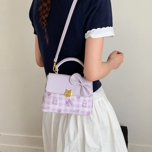 Detail of lavender square bag with bow, cat buckle and adjustable crossbody strap